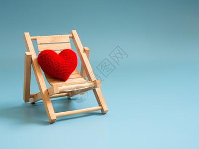 美丽的躺椅象征蓝屏幕背景孤立复制文本空间用于情人节爱概念和背景的文字空间在蓝屏背景上绘制的木沙滩椅上红色心背景图片