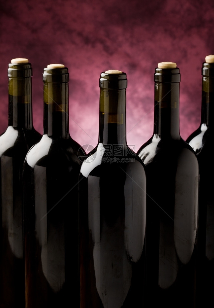 瓶子五葡萄酒在紫罗兰背景面前的照片酒吧正面图片