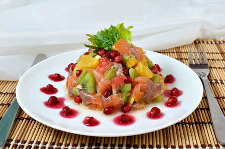 沙律加不同水果和石榴的鲑鱼产品刀具午餐图片