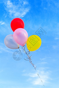 庆祝抽象的蓝色天空背景上的多彩气球节日图片
