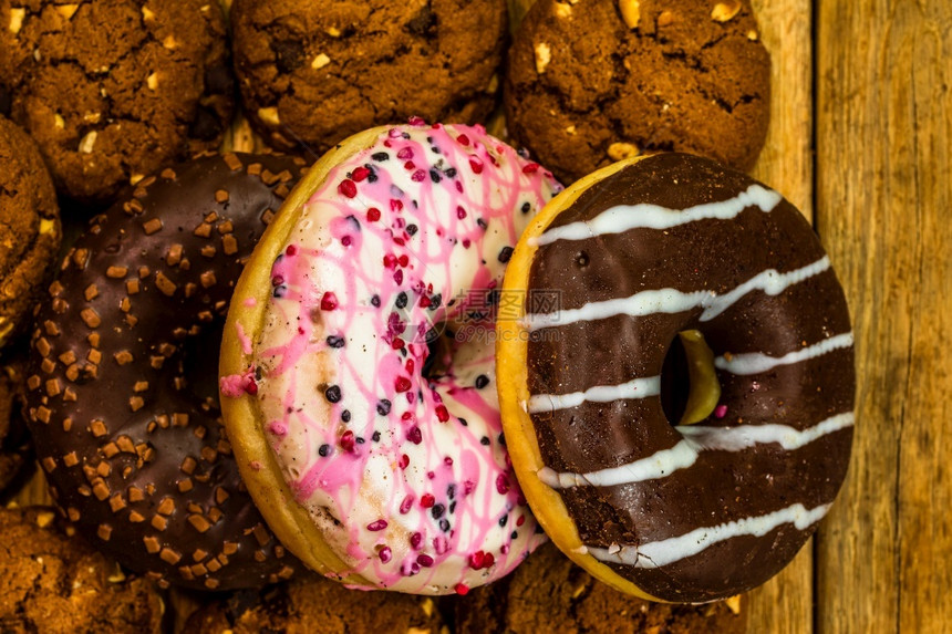 甜冰糖食品配有胶水喷发甜圈和巧克力霜冻的面色及复制空间丰富多彩的美食木制图片