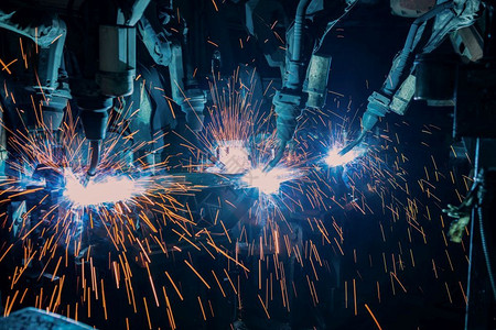 生产火花未来派团队工业机器人在厂中焊接金属部分图片