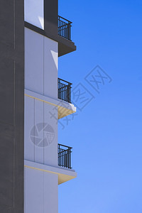 垂直框中蓝色清晰天空背景的高住宅楼面阳台低角和侧视图垂直框中蓝亮天空背景框架泰国灰色的图片