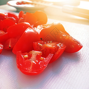 白色切割板上樱桃番茄片的近视烹饪和健康食品概念蔬菜美味的圆圈图片