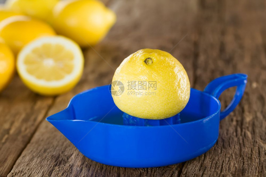 或者健康蓝柠檬挤压器的一半背面有柠檬在木材选择焦点上拍照聚柠檬一半的端柠檬奎泽上的茶点图片