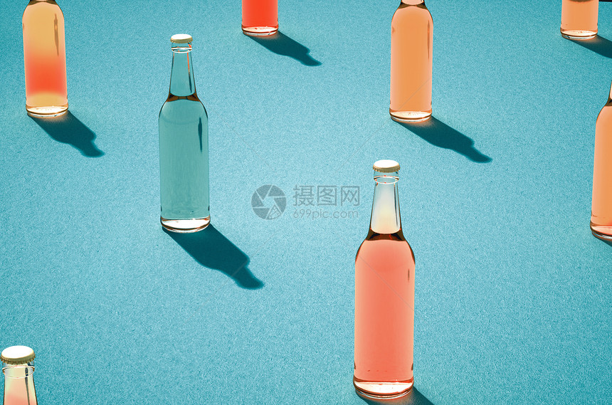 寒冷的几个玻璃啤酒瓶有浅蓝色背景的阴影各种没有标签的彩色玻璃瓶Retro饮料瓶概念反射照片图片