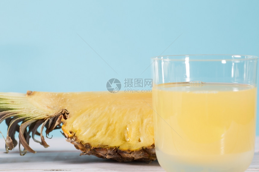液体甜的白色蓝背景新鲜菠萝汁图片