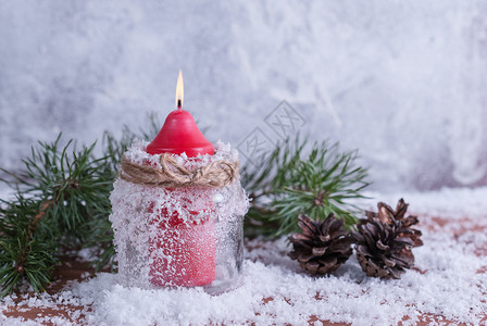 木制的问候圣诞节红色的蜡烛树枝和锥形红蜡烛放在雪覆盖的木制本底图片