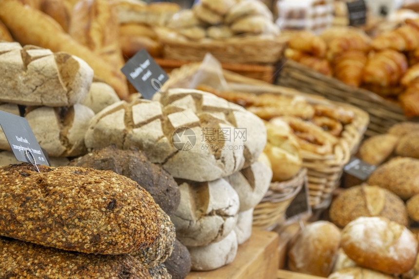 有机的在阿姆斯特丹荷兰农民市场许多种类的面包和羊角前景上的标志写着法国面包可口图片