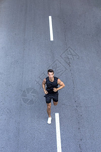 合身赛跑者前面是黑运动服在路边训练运动员跑步者年轻的图片