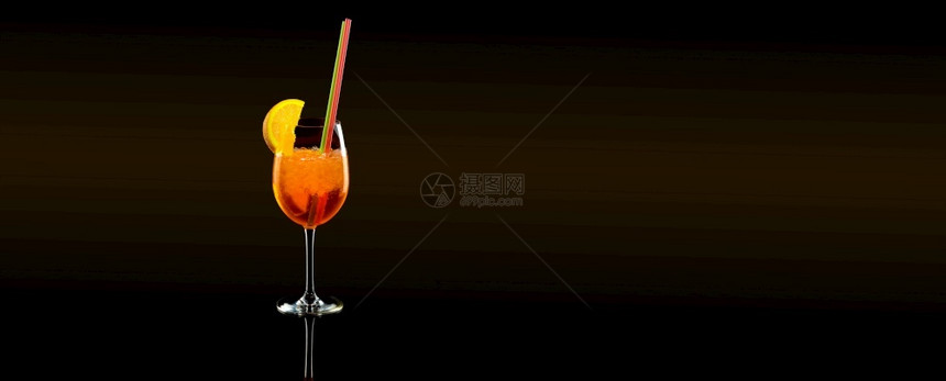 酒保开胃橙色玻璃中的阿珀罗醇注射器黑色背景上含管状体的夏季鸡尾酒喝图片