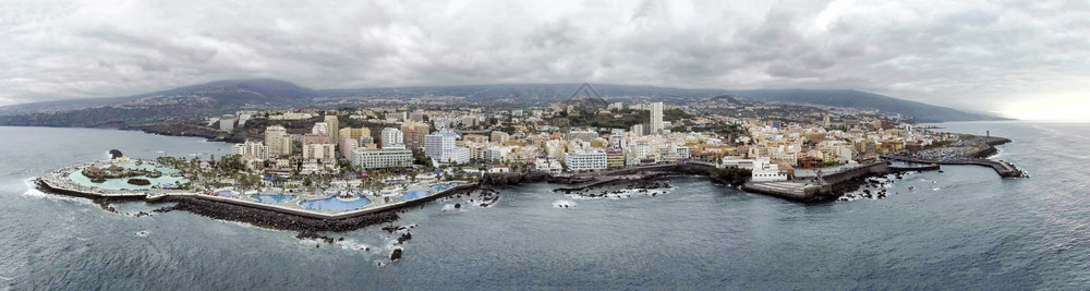 从无人驾驶飞机对西班牙岛特内里费海岸线的空中观察水建造城市图片