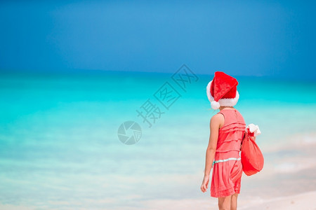 克劳斯圣诞度假海滩上的孩子热带沙滩上圣诞帽的可爱亲小女孩乐趣戏服图片
