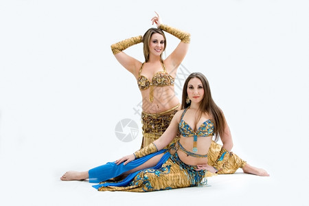 快乐的两名漂亮腹部舞女身着金色和蓝孤立无援女孩们表演者图片
