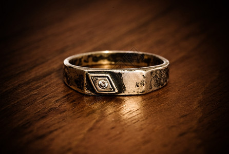 肮脏的戒指木桌上的旧银环单身灰色铺设背景