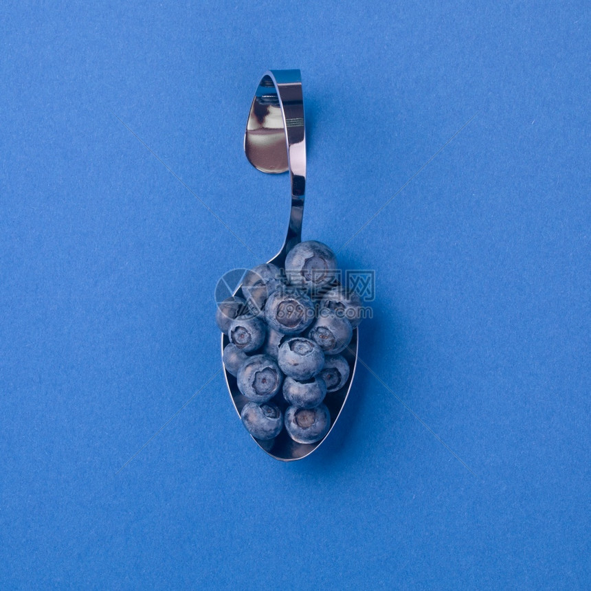 勺子美食物蓝色背景莓的圆曲铬汤匙图片