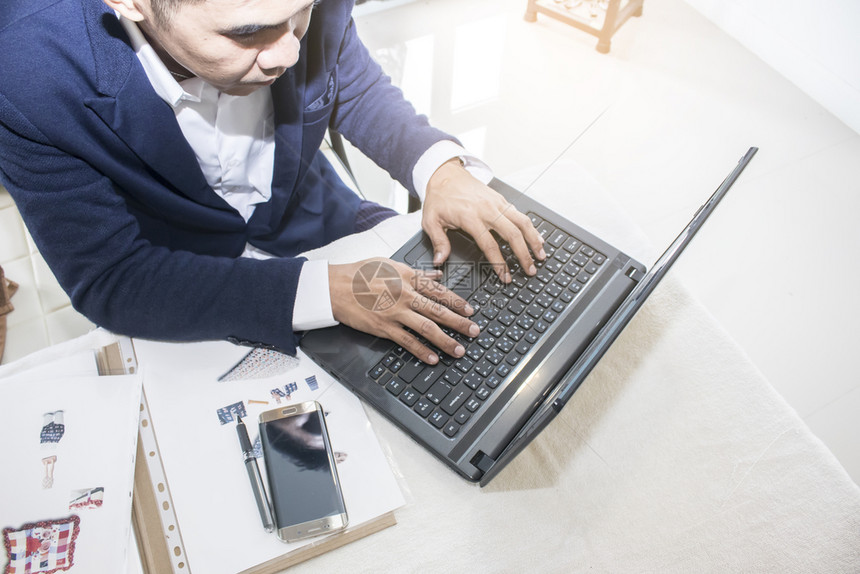 在办公室膝上型计算机打入男子商业务桌面工作忙碌的图片