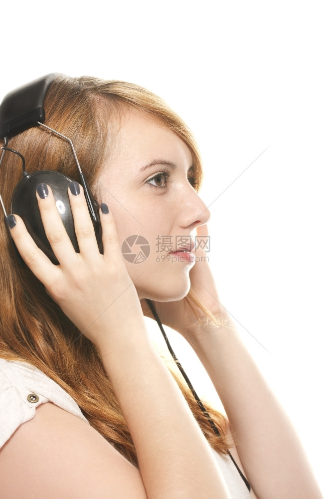 梦幻般的年轻红发女郎戴着耳机听音乐梦幻般的年轻红发女郎戴着耳机在白色背景上听音乐做梦女年轻的图片