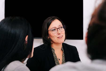 商业妇女当着办公室同事的面说话在她办公室的同事面前讲话会议专业的团体图片