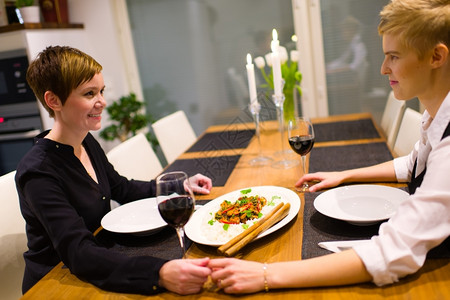 女友谊快乐的一对女夫妇坐在晚餐桌上一起玩得开心团结图片