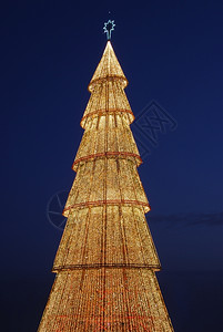 十二月紧贴在一棵美丽高的圣诞树上灯丝带图片
