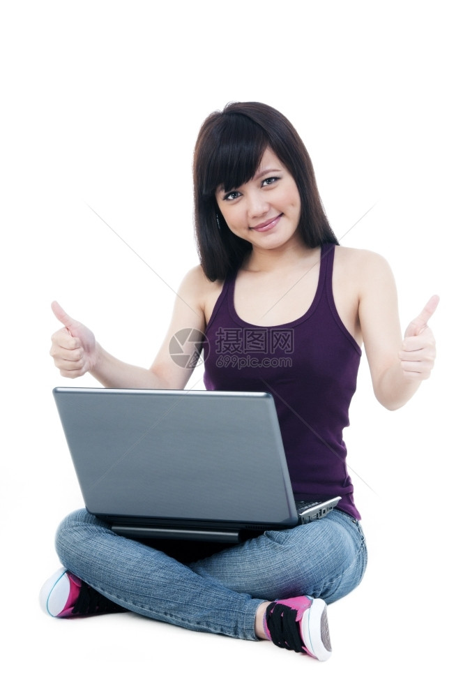 颜色随意的一个可爱年轻女孩肖像用笔记本电脑坐在地板上白背景举起拇指标志成功图片