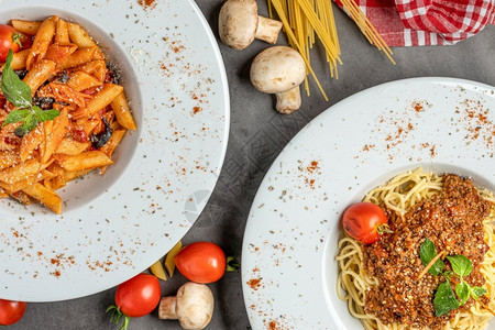 意大利语帕尔马干酪可口面粉和薄意大利西红柿和黑石桌上的烤肉图片