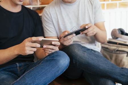 青年男子在智能手机游戏中一起玩耍和竞争的图像亚洲人兴奋的在线图片
