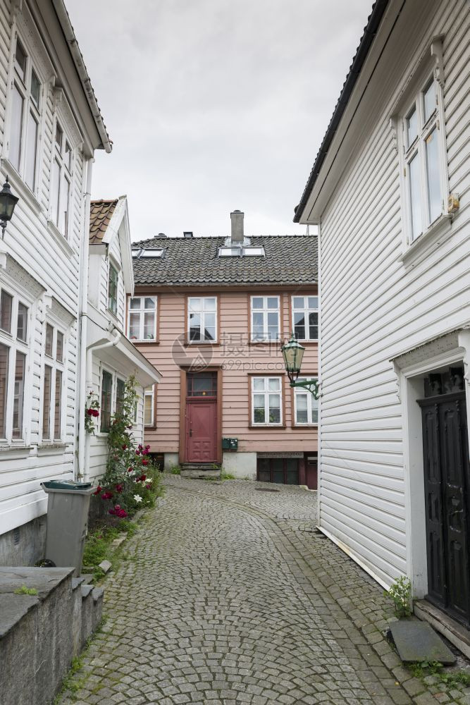 老的城市挪威卑尔根的典型街道白木屋和鲜花在街上建造图片