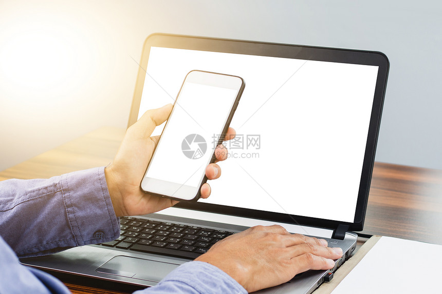 笔记本现代的使用智能手机移动式互联网技术的手在办公室工作移动的图片