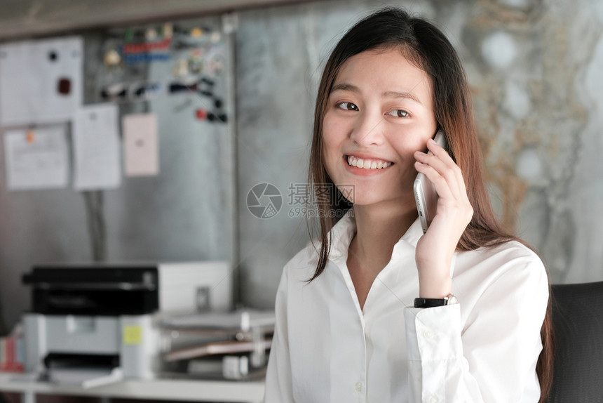 工人笔记本电脑在职的办公桌工作和讲电话的年轻亚洲女商业人余休闲生活方式和在办公桌工作并通电话的图片