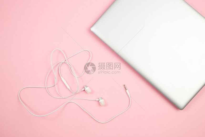 白色的粉红孤立背景顶见底的白带线耳机和笔记本电脑缆无线的图片