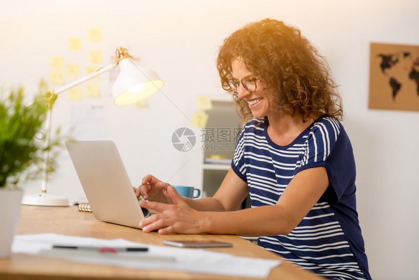 办公室使用笔记本电脑的中年妇女行政人员坐着工作图片