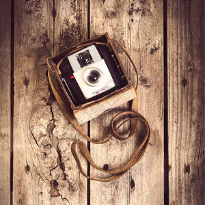 旧皮革案的相机在木制背景过滤器上被优质的盒子照片图片