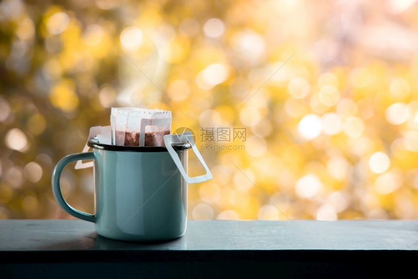 停留家在清晨喝热饮时将咖啡冲出门外的由即时桶装袋可舒适的生活方式制作杯子图片