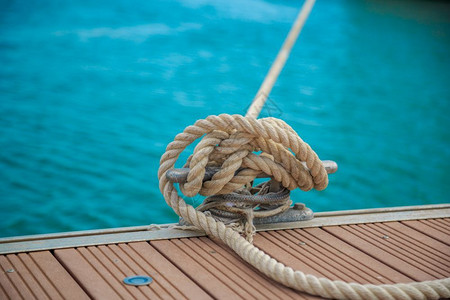 结将游艇绳系在木制码头上紧绑在一扇锁链上航行种图片
