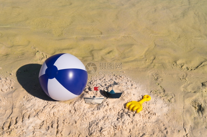 采取孩子海滩上一些玩具像球和纸船一样户外图片