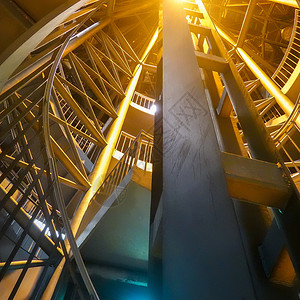 角度夜间记录从地下平台通往大楼外部的明亮螺旋楼梯由地下平台到大楼外面的灯光螺旋楼梯步圆形的背景图片