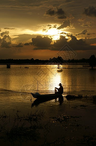 船上的渔民在日出洪水季节河上捕鱼颜色夏天云图片