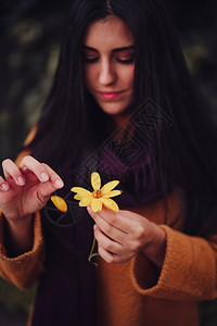 手迷信年轻女在田里采黄色花朵白天图片