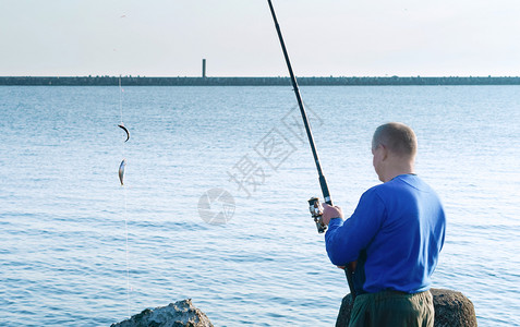 海边钓鱼的男子图片