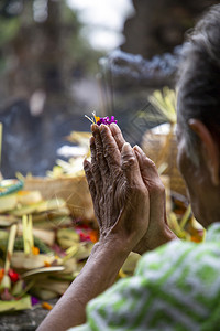 信仰在巴厘的印度寺庙里老妇人与猎物手起祷告巴厘岛受害者图片