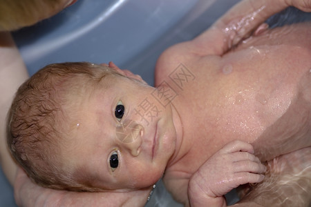 身体享受洗澡的可爱小男孩享受母亲手中的洗澡可爱新出生小男孩乐趣裸图片