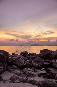 轮廓岩石垂直视图下日落的海滩岸图片