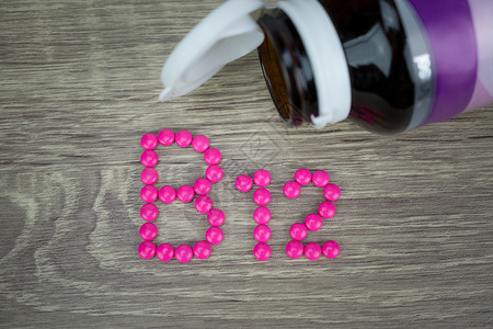 b12型成粉碎药丸形状在木背景A上按B12字母顺序排列健康瓶子营养背景