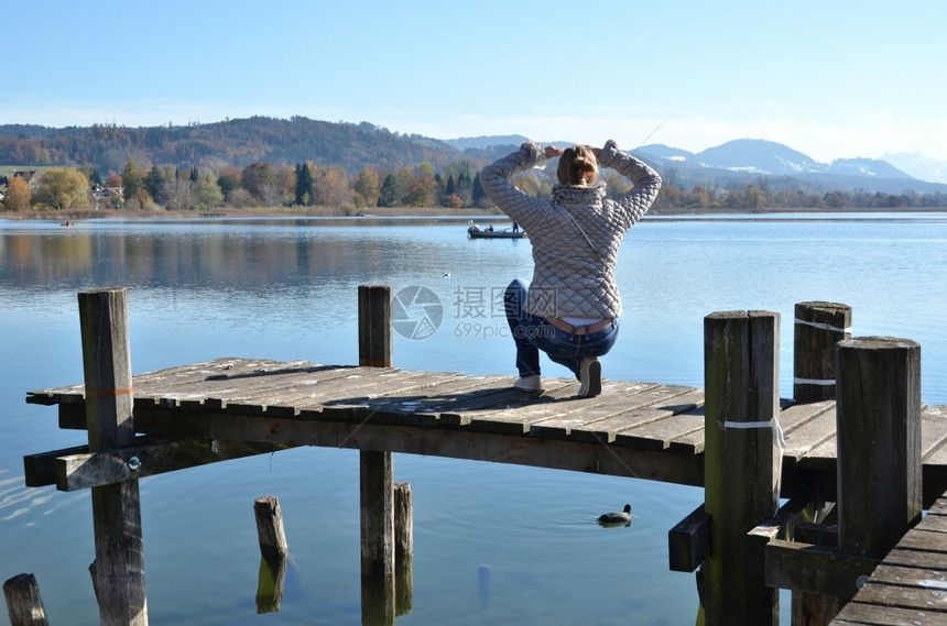 柴金在木制码头对瑞士湖的女孩孤独图片