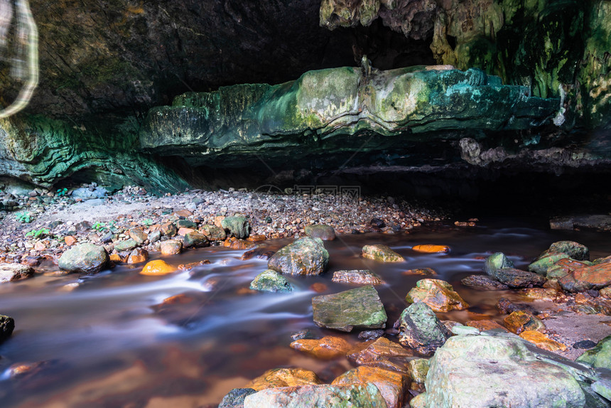 亚洲荒野公园小瀑布洞穴里有石头和树叶图片