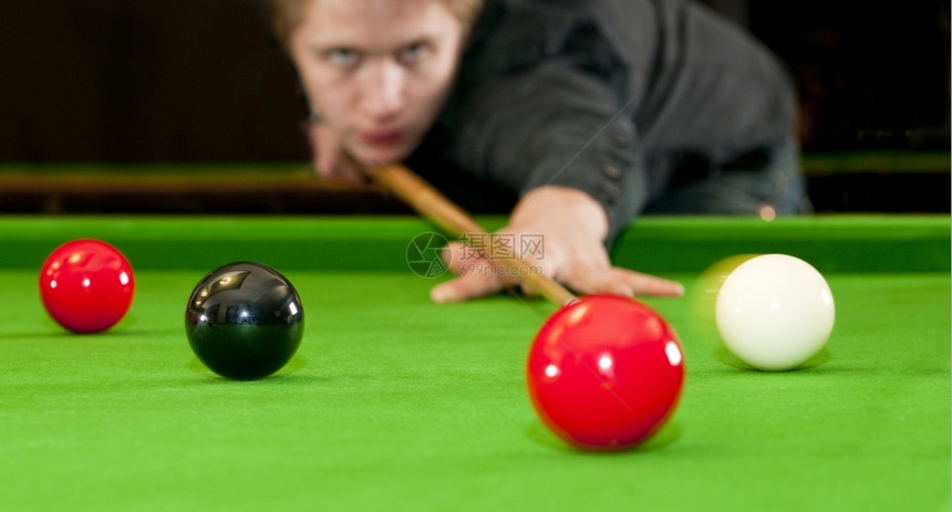 球员弹跳Snooker播放器将提示球置在黑镜头上同时打红球选择焦点和运动模糊斯诺克图片
