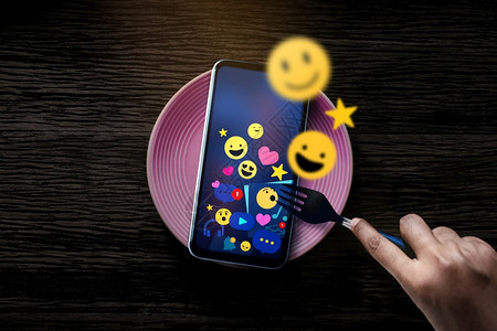 在数字世界桌面最佳视图中使用叉口吃早餐的名词概念相片人与社会媒体Emoji在移动电话线例行日常生活方式和技术上的Emoji图标网设计图片