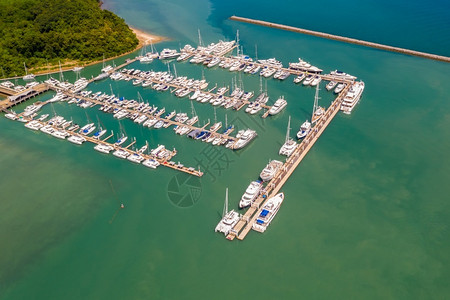 普吉岛游艇多于城市的天线无人驾驶飞机从泰国普吉岛绿海上空的游艇和快停泊背景